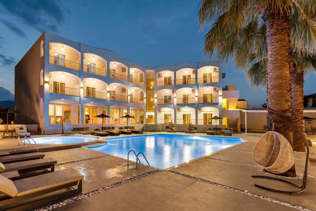 un hotel con piscina frente a un edificio en Stavros Beach Hotel en Stavros