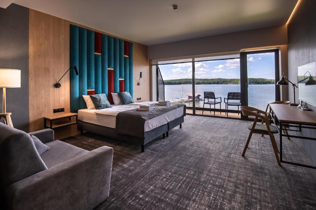 a hotel room with a bed and a view of the water at OTTON-Charzykowy Bed&Restaurant in Chojnice