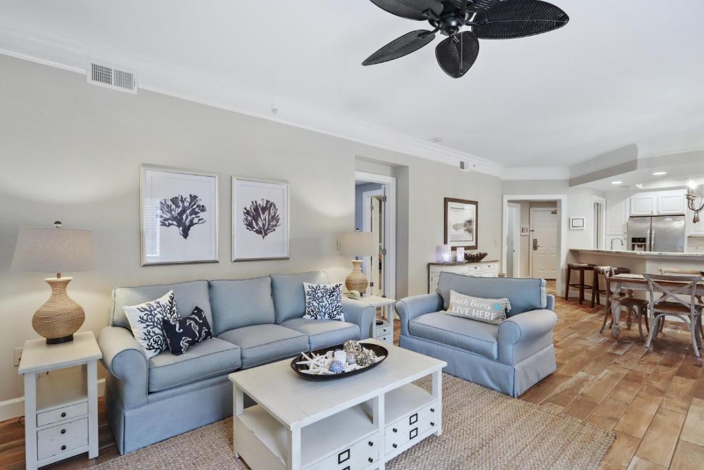 a living room with two blue couches and a table at 8121 Wendover Dunes in Hilton Head Island