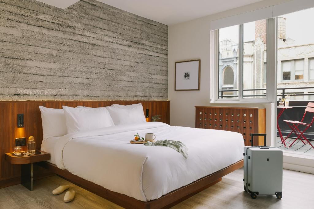 ein Schlafzimmer mit einem großen weißen Bett und einem großen Fenster in der Unterkunft Sonder Henri on 24 in New York