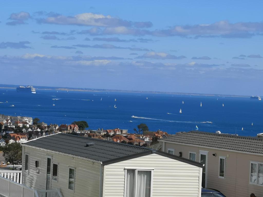 a view of the ocean from the roofs of houses at Top Spec Caravan - Stunning sea views across bay in Swanage