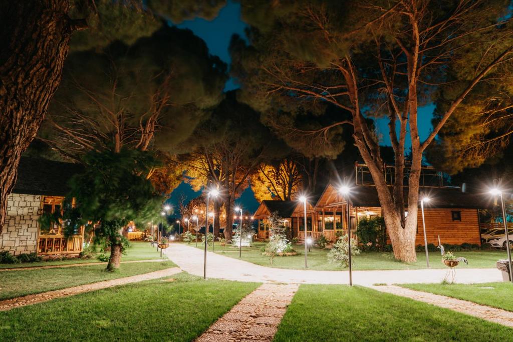 un parque iluminado por la noche con luces de la calle en Pino Mar Luxury Bungalows, en Erdek