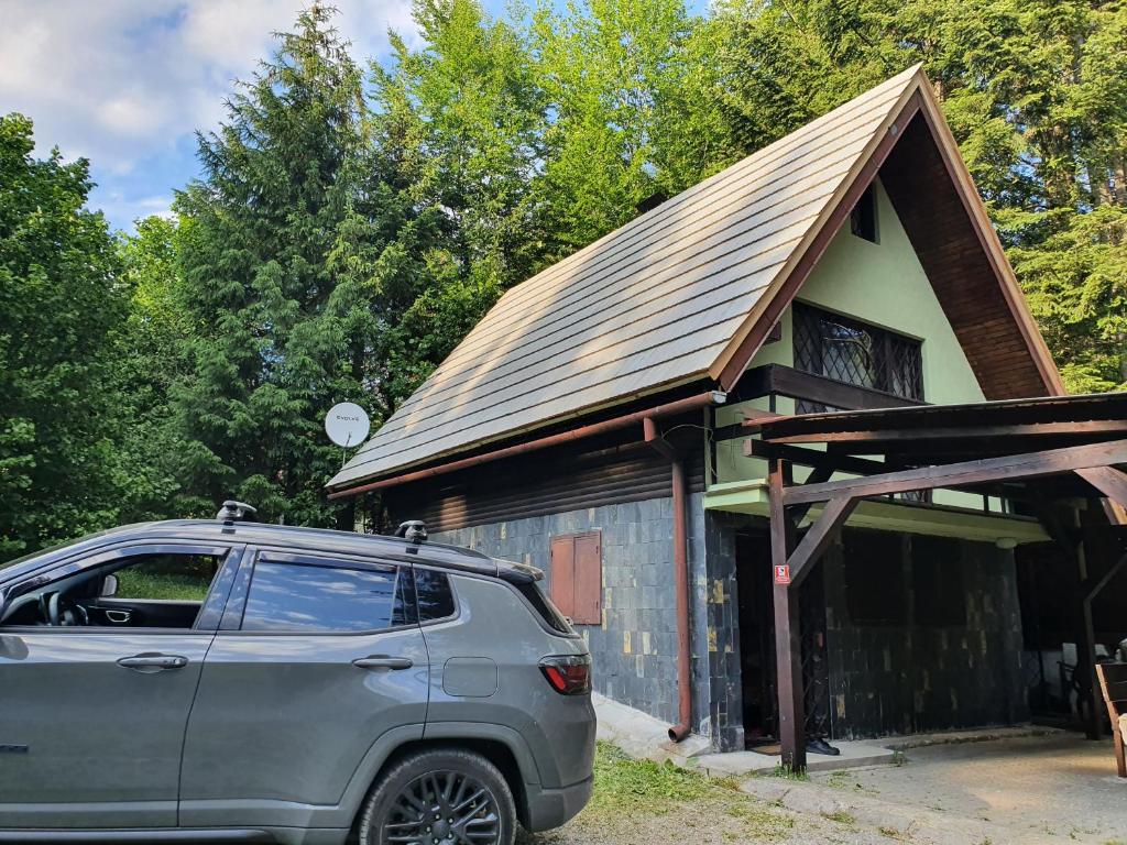 un'auto parcheggiata di fronte a una piccola casa di Krpáčovo, Nízke Tatry - chata na kraji lesa a Dolná Lehota