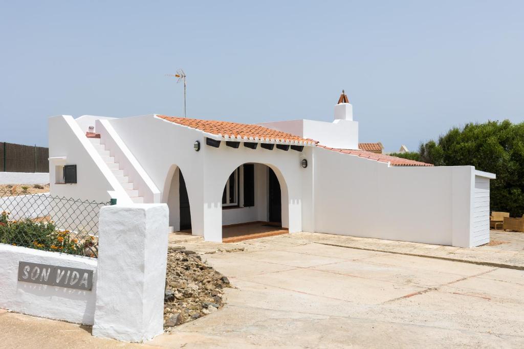 une maison blanche avec un escalier dans une cour dans l'établissement Holiday Home - Son Vida, à Port Mahon