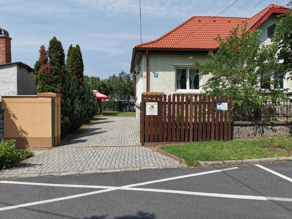 a house with a fence next to a street at Glázer Szállás in Tapolca