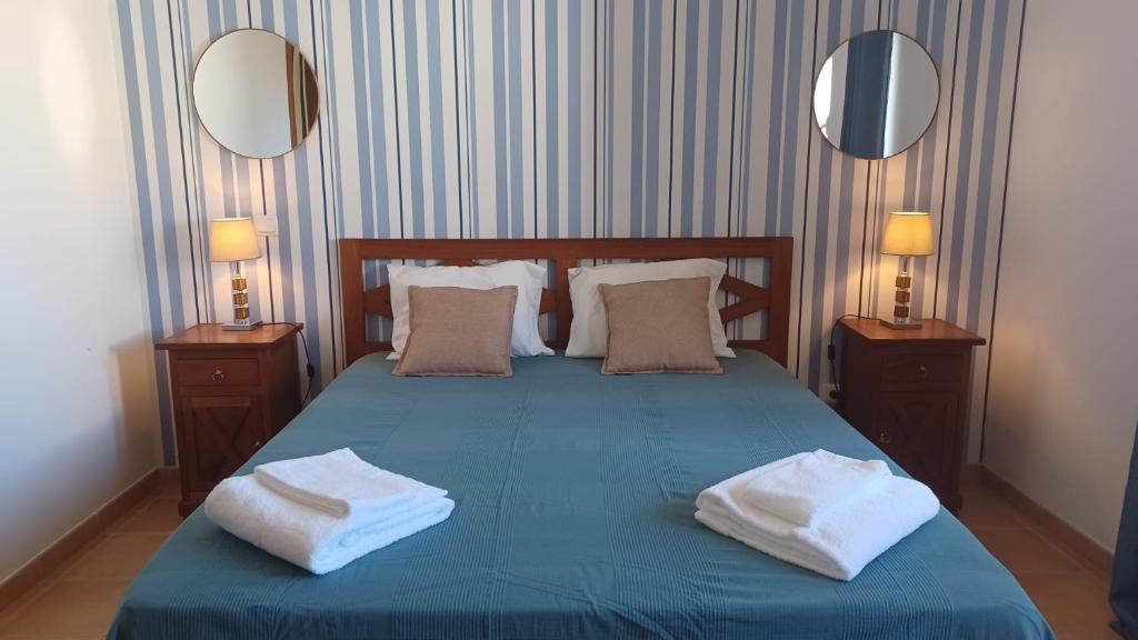 a bedroom with a blue bed with two towels on it at Quinta Velha 22 in Tavira