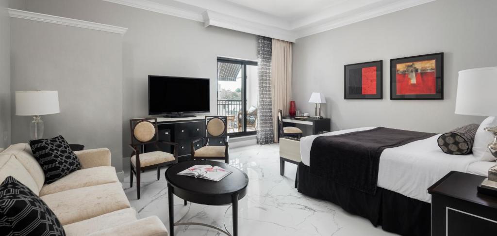 a hotel room with a bed and a couch and a tv at Inn On Fifth in Naples