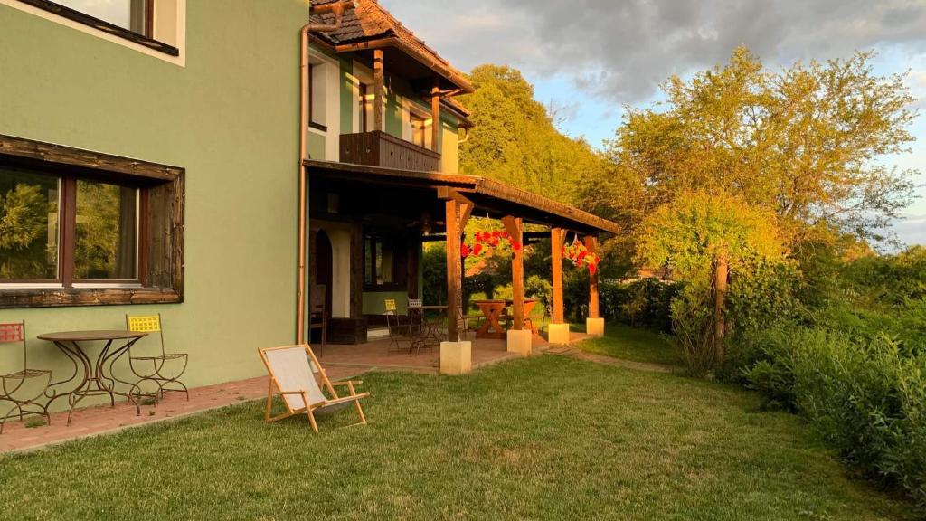 ein Haus mit einem Tisch und Stühlen im Hof in der Unterkunft Szejke Villa in Odorheiu Secuiesc