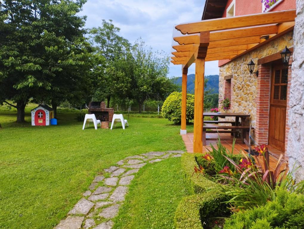 a patio with a table and chairs in a yard at Casa Rural El Jondrigu in Cangas de Onís