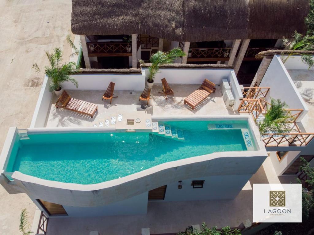 una vista aérea de una piscina con sillas y una playa en Lagoon Boutique Hotel - Luxury Chaman experience, en Tulum