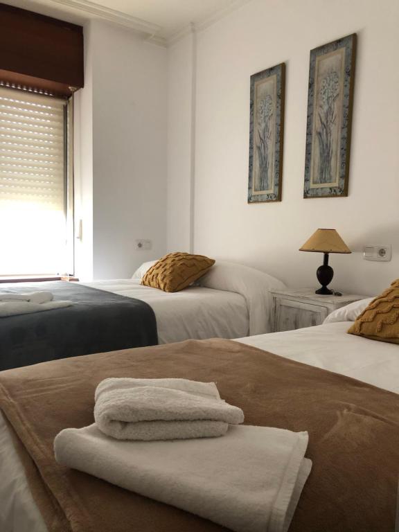 um quarto com 2 camas e toalhas em FIFA em Arzúa