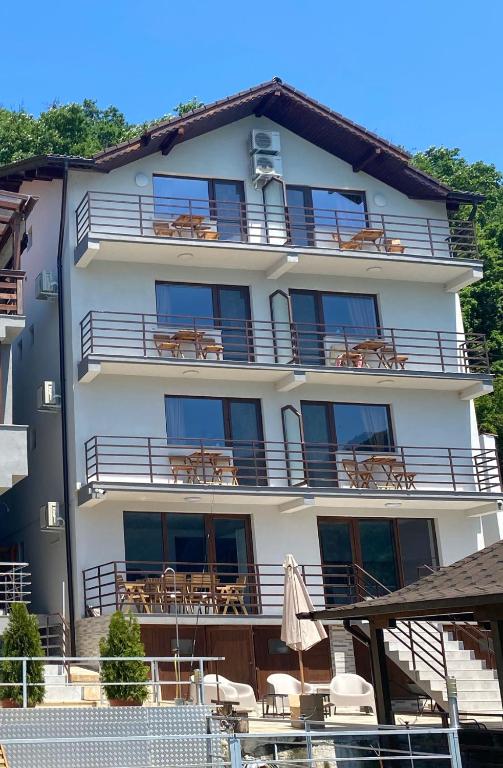ein großes weißes Gebäude mit Tischen und Stühlen in der Unterkunft Vila Levitas in Dubova