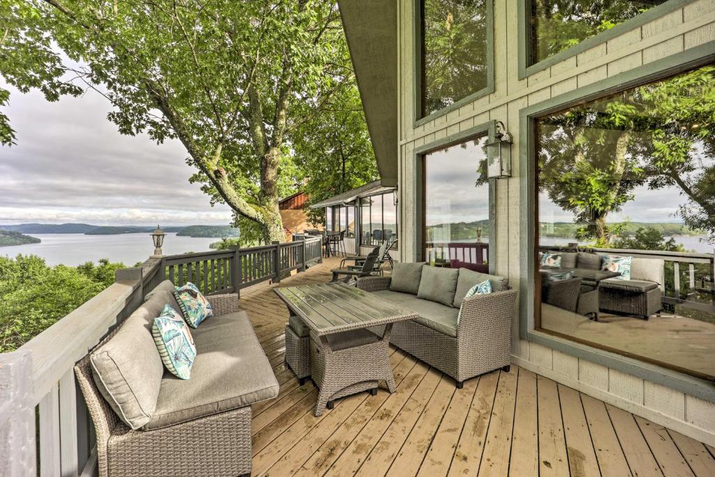 een afgeschermde veranda met stoelen en een tafel bij Spacious Beaver Lake Home with Stunning Views! in Garfield