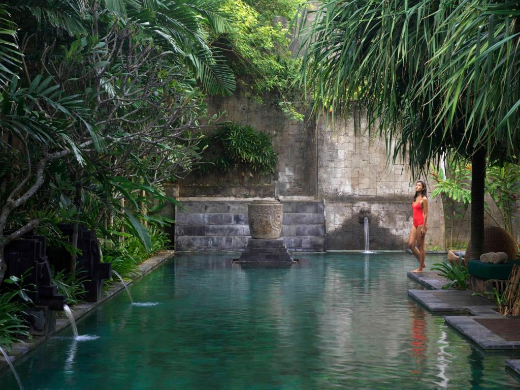 a man and a woman bathing in a pool of water at Hotel Indigo Bali Seminyak Beach, an IHG Hotel in Seminyak