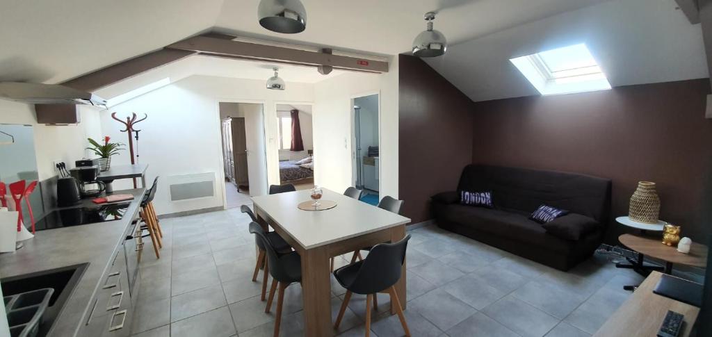 eine Küche und ein Wohnzimmer mit einem Tisch und einem Sofa in der Unterkunft Appartement meublé classé 2 étoiles tout confort Lagor in Lagor