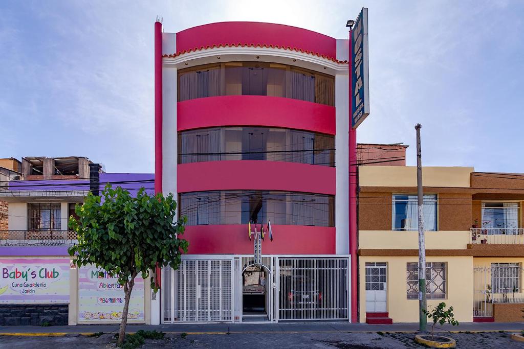 a red building with a sign in front of it at Hotel Musuk Wasi in Arequipa