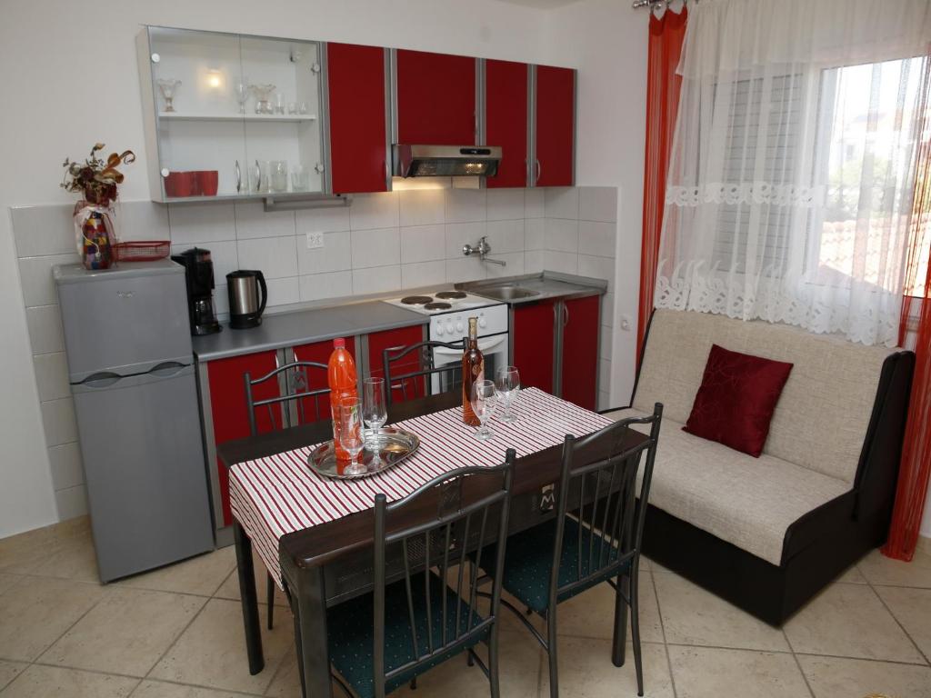 a kitchen with a table and a kitchen with a couch at Apartments M&R ŠPADINA in Vodice