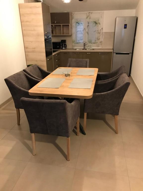 a dining room table with chairs and a kitchen at Albatros in Kastel Sucurac