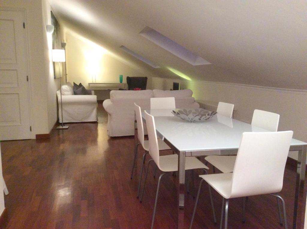 a living room with a white table and white chairs at Apartment La Mansarda in Alba