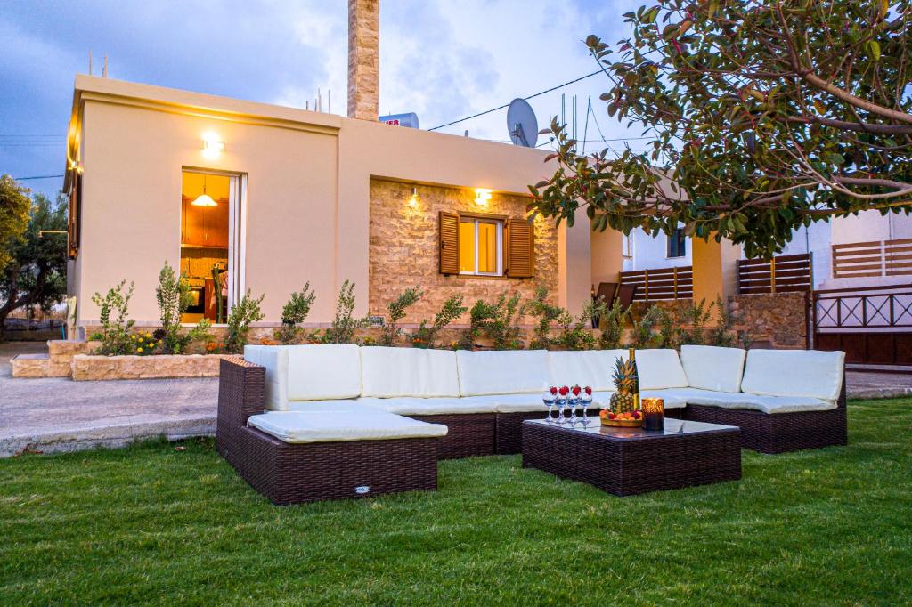 a backyard with a white couch and a table at Villa Ciel in Agios Padeleimon