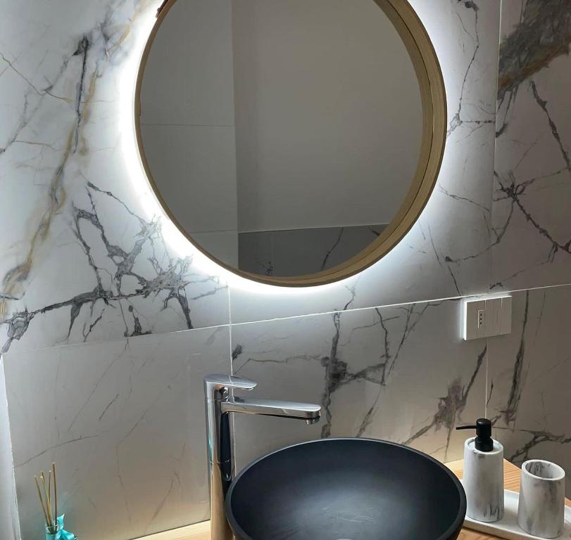 bagno con specchio rotondo e lavandino di Maison Aida a Porto SantʼElpidio