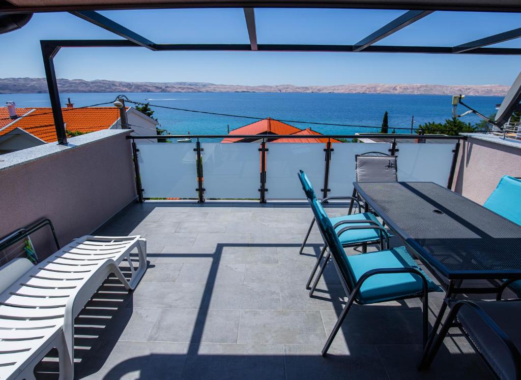 a balcony with a table and chairs and the water at Apartments Julia & Nika in Karlobag