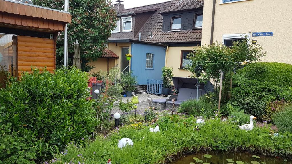 a garden with a pond in front of a house at Ferienwohnung in Gartenlandschaft in Kassel