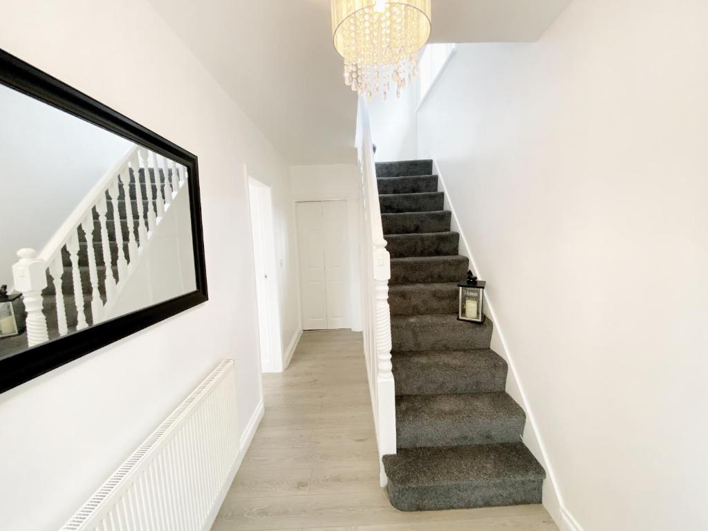 a staircase in a house with a chandelier at Luxurious family home in West Midlands in Northfield
