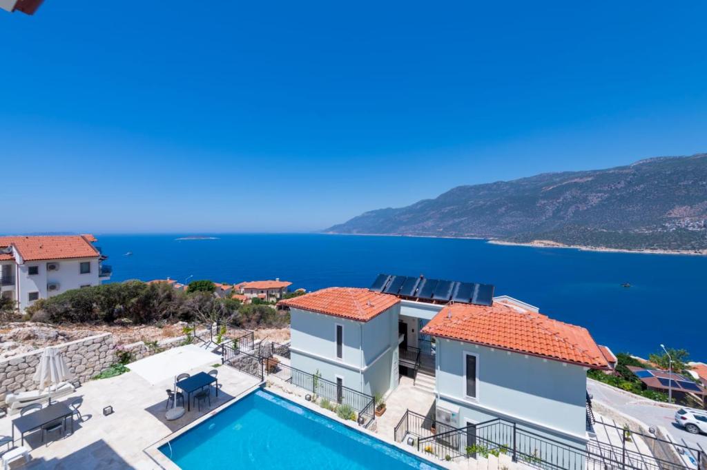 a villa with a swimming pool and a view of the ocean at Gümüş Yazar Hotel in Kaş