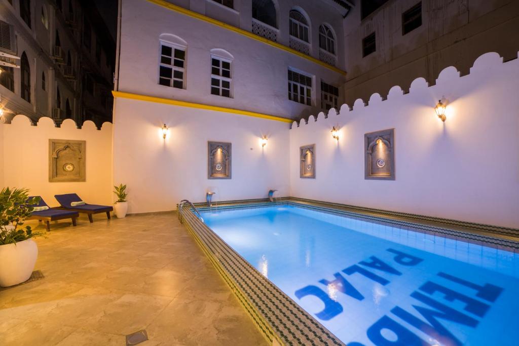 a large swimming pool in a building with a swimming pool at Tembo Palace Hotel in Zanzibar City