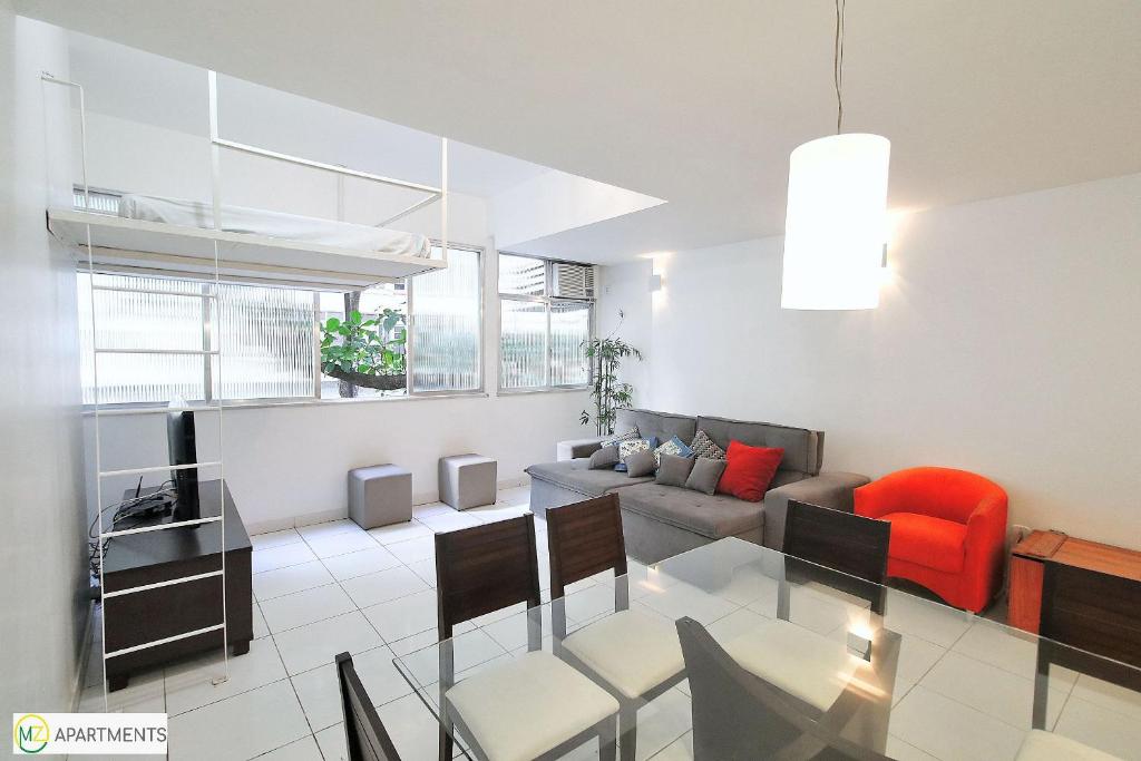 een woonkamer met een bank en een tafel bij Apartamento 2 quartos espaçoso no Leme in Rio de Janeiro