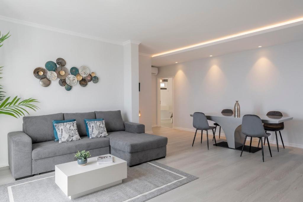 a living room with a couch and a table at Intelsol Calheta Apartments by An Island Apart in Calheta