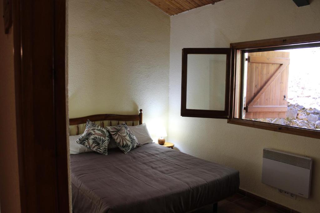 a bedroom with a bed with a window and a bed sidx sidx sidx at Casa Teresina in La Plana de Mont-Ros