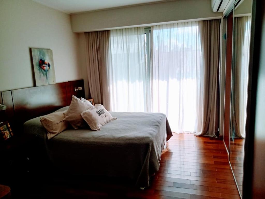 a hotel room with a bed and a large window at Estudio Paraná in Rosario