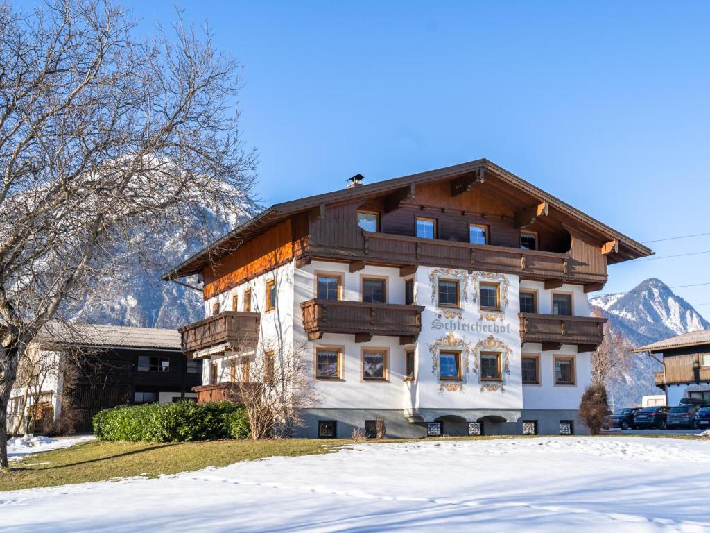 a large building with snow in front of it at Schleicherhof II in Strass im Zillertal