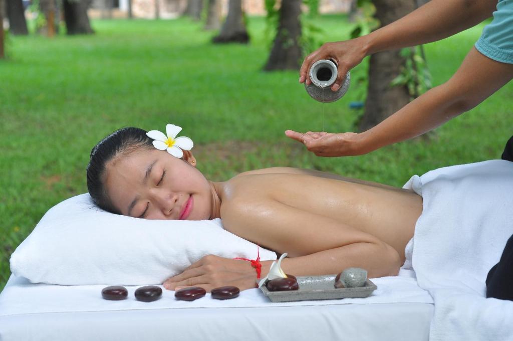 a woman laying on a bed getting a massage at Lotus Blanc Resort in Siem Reap