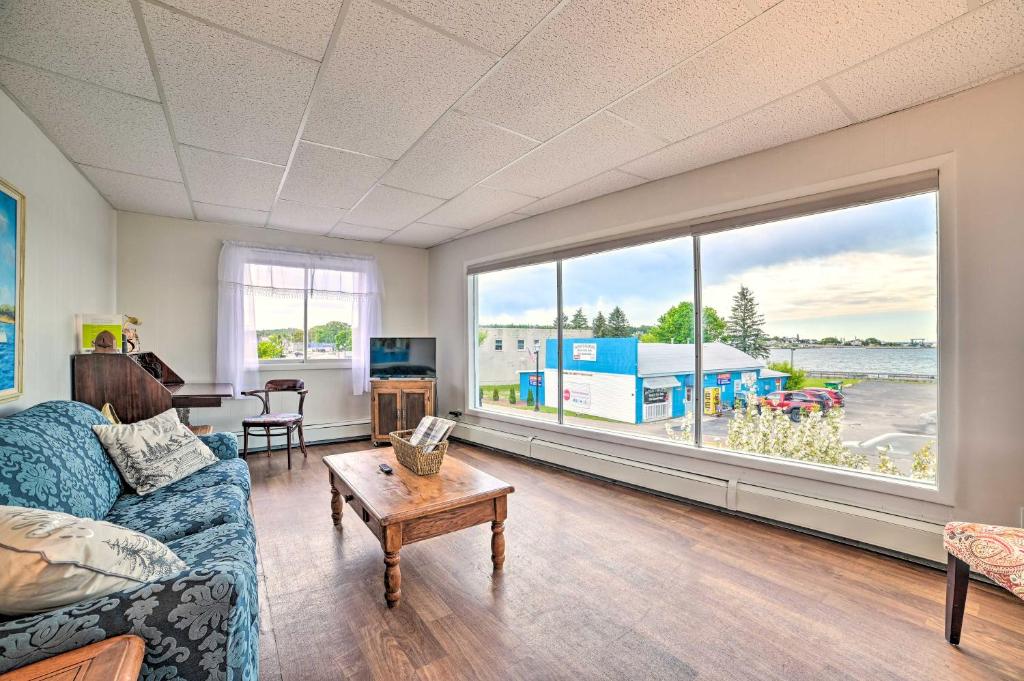 a living room with a blue couch and a large window at Walkable St Ignace Condo with Lake Huron Views in Saint Ignace