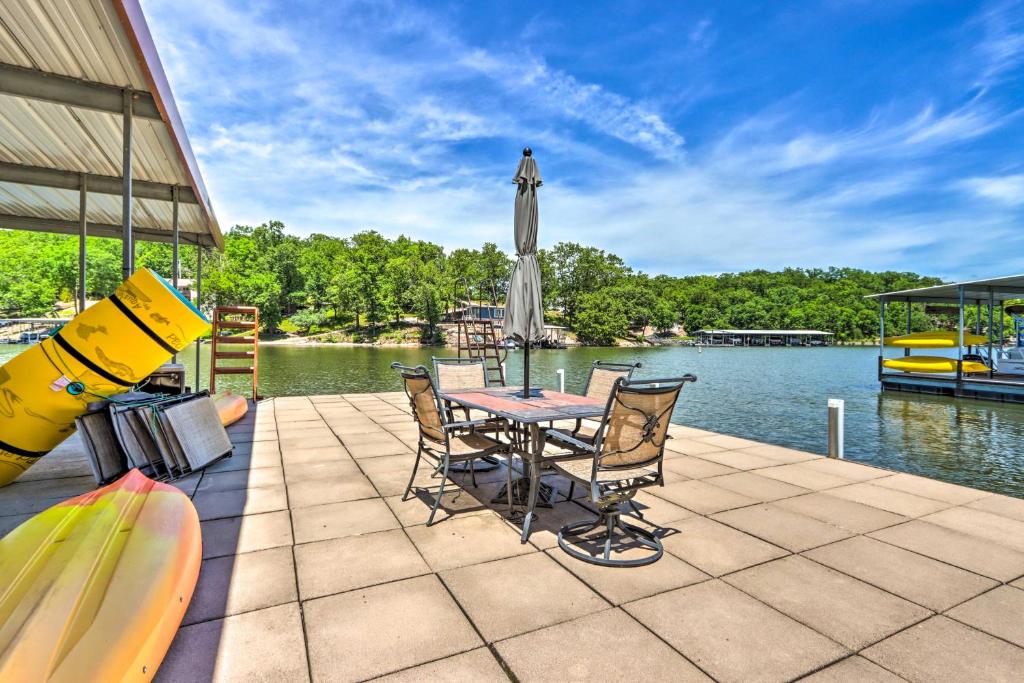 un patio con tavolo, sedie e barca di Waterfront Home with 3 Decks on Lake of the Ozarks! a Sunrise Beach