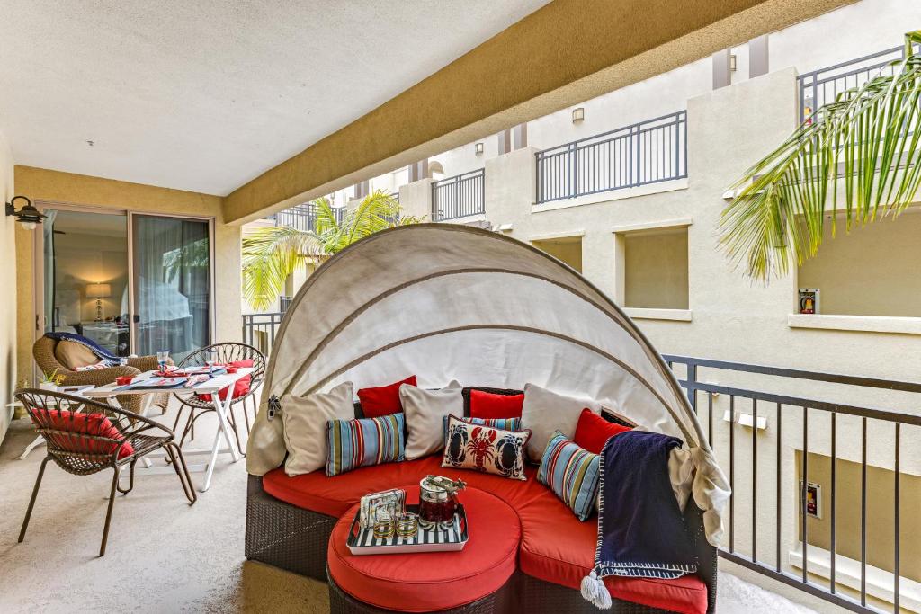 un soggiorno con divano rosso sul balcone di Seacliff Retreat Gorgeous third-floor condo with pool, hot tub, & fitness room - walk to beaches a Oceanside