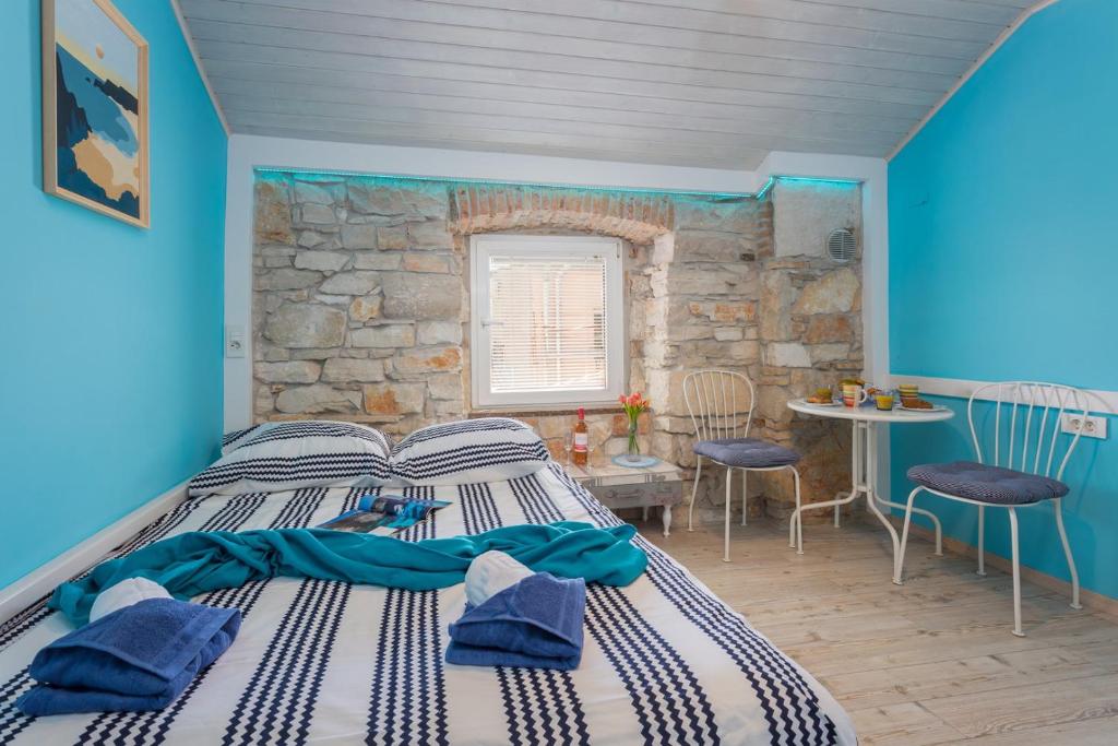 a bedroom with a bed and a stone wall at Clerisseau Apartments in Pula