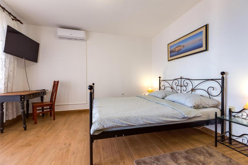 Schlafzimmer mit einem Bett, einem Tisch und einem Schreibtisch in der Unterkunft Apartments Sabina, Mali Lošinj in Mali Lošinj
