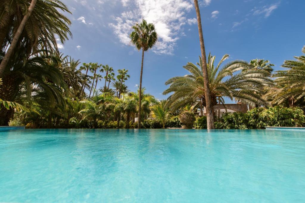 una gran piscina con palmeras en el fondo en Eden Meloneras by TAM Resorts en Maspalomas