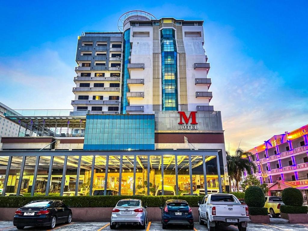 a large building with cars parked in front of it at M Hotel Danok in Sadao