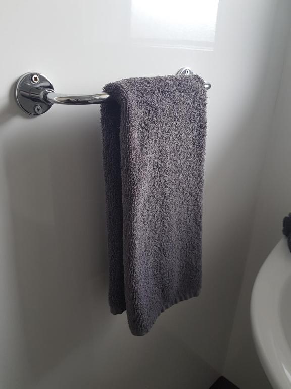 un asciugamano appeso a un portasciugamani in bagno di A'Abode Motor Lodge a Palmerston North