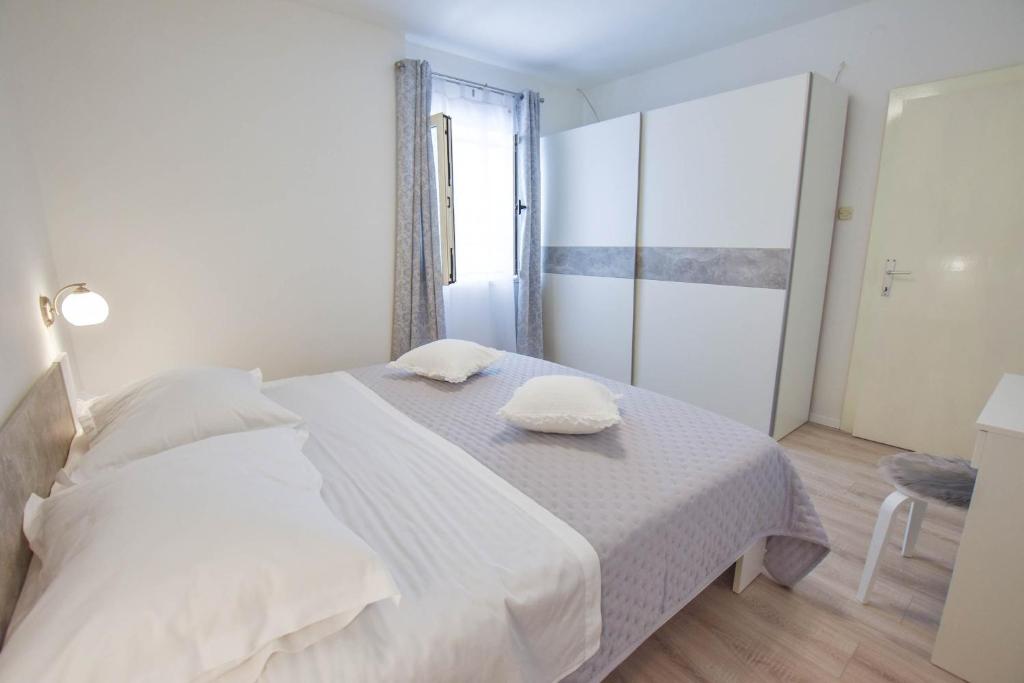 sypialnia z białym łóżkiem i 2 ręcznikami w obiekcie Apartment S and E w mieście Kali