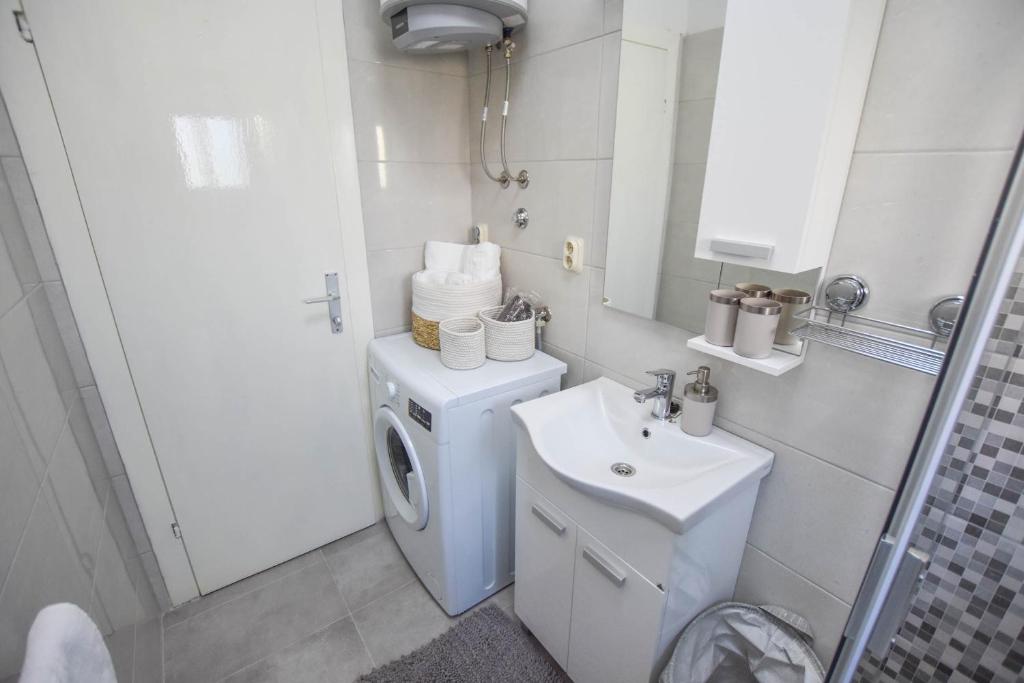 W łazience znajduje się pralka i umywalka. w obiekcie Apartment S and E w mieście Kali