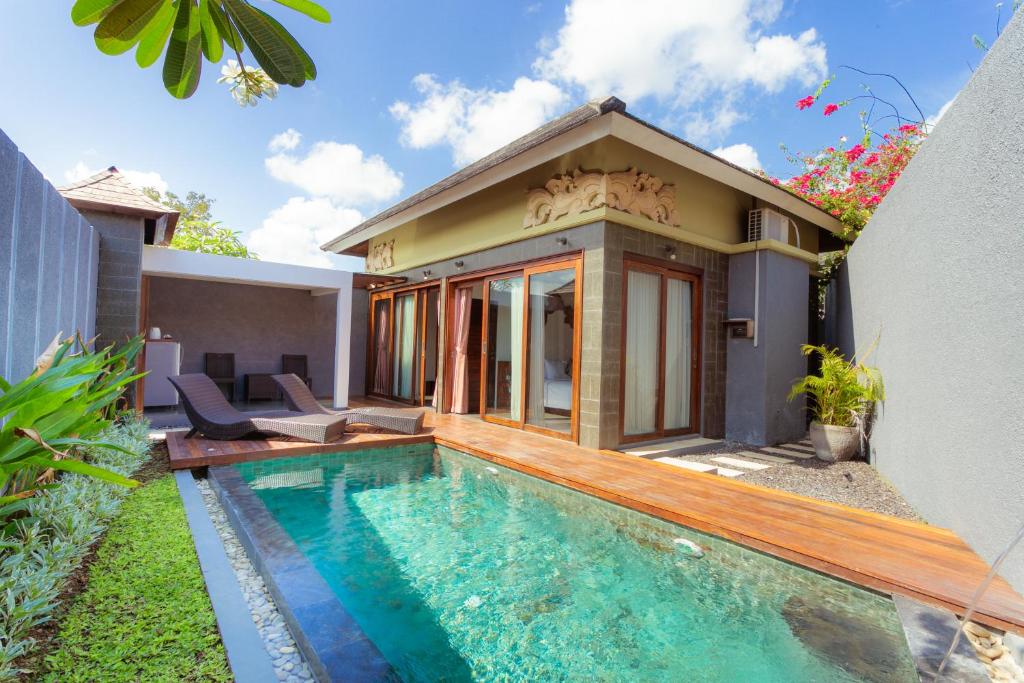 a house with a swimming pool in front of a house at The Canggu Boutique Villas & Spa by ecommerceloka in Canggu