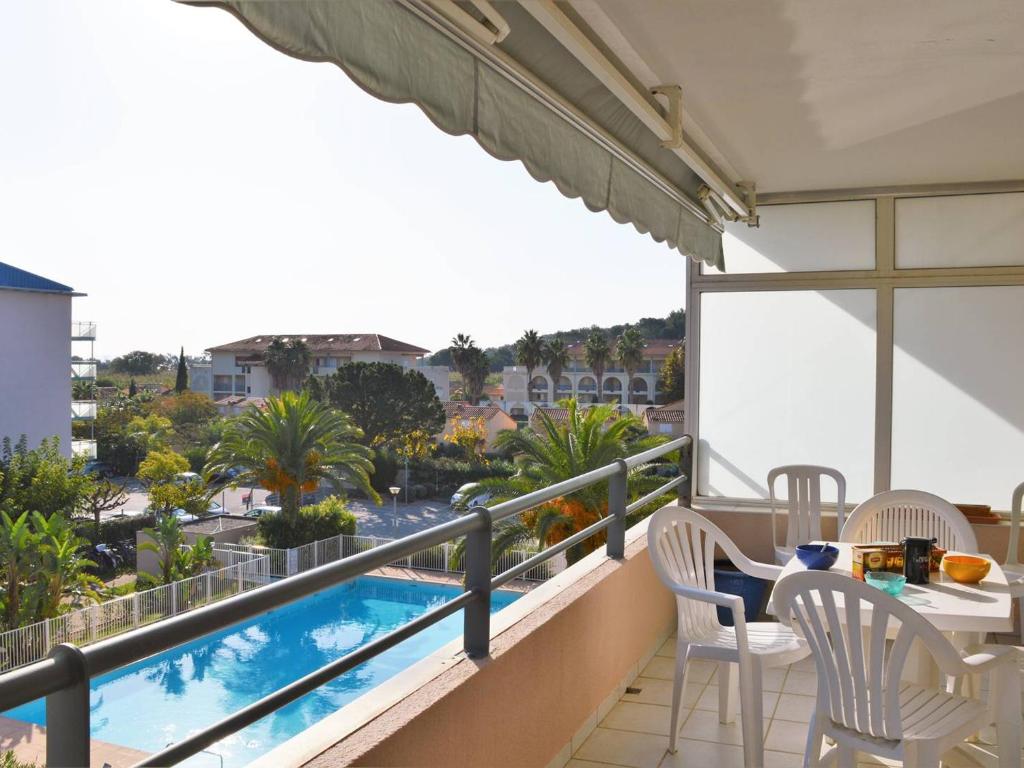 d'un balcon avec une table et des chaises, ainsi que d'une piscine. dans l'établissement Appartement T2 climatisé avec piscine, terrasse et parking à 600m de la plage - Le Lavandou - FR-1-251-399, au Lavandou