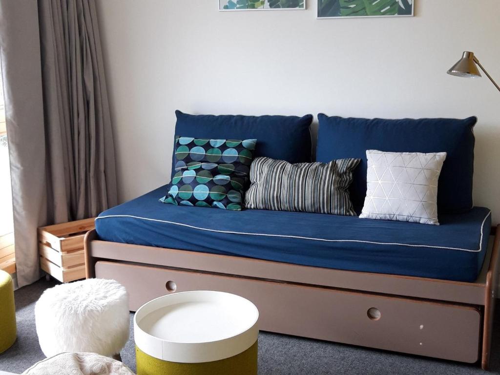 - une chambre avec un canapé bleu et des oreillers dans l'établissement Appartement rénové calme avec balcon, wifi, parking inclus, proche Transarc et commerces - FR-1-346-306, à Arc 1800