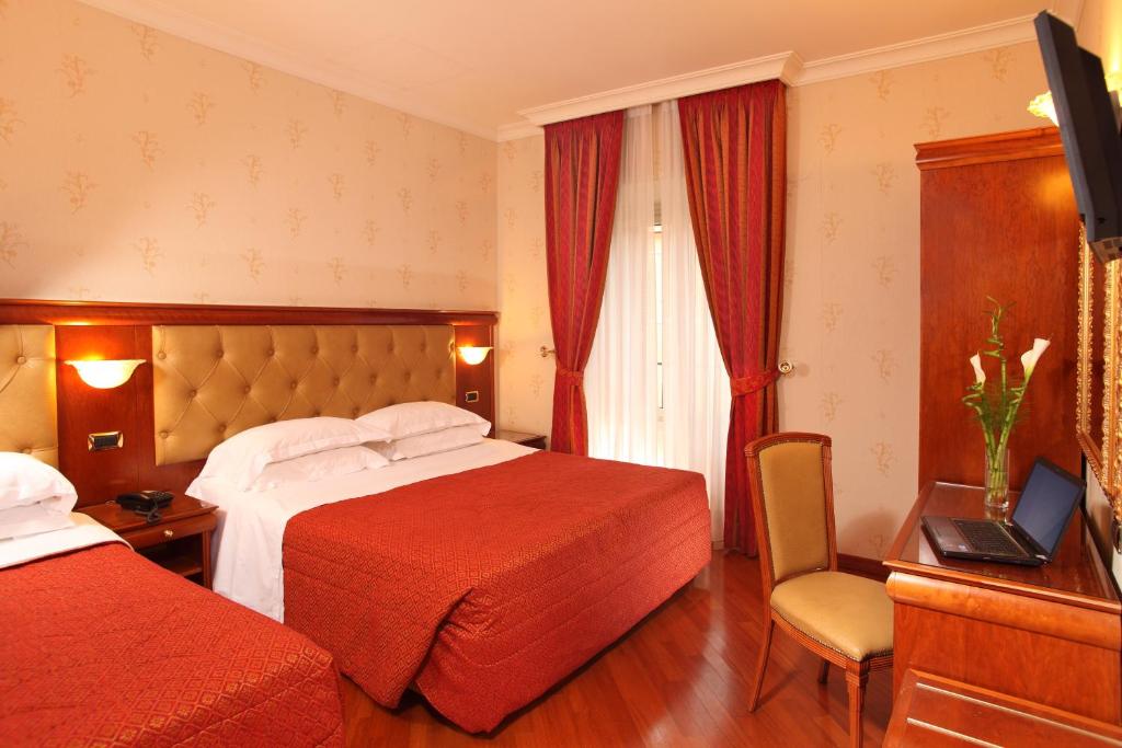 a hotel room with two beds and two lamps at Hotel Serena in Rome